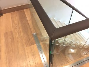 Leather covered handrails on glass balustrade